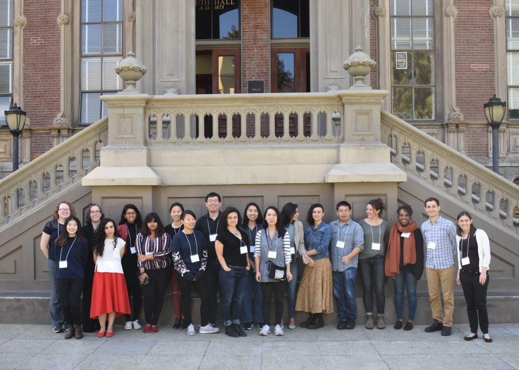 a group of people stand in front of a brick building